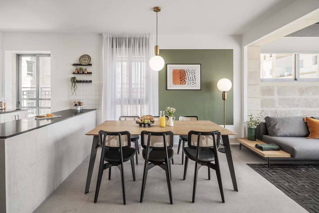 Dining table, kitchen and living area of a furnished apartment at Mr. Agrippa in Jerusalem, with Jerusalem-stone walls
