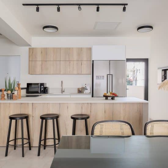 Fully equipped kitchen with island and bar stools in a TLV2GO apartment, Tel Aviv