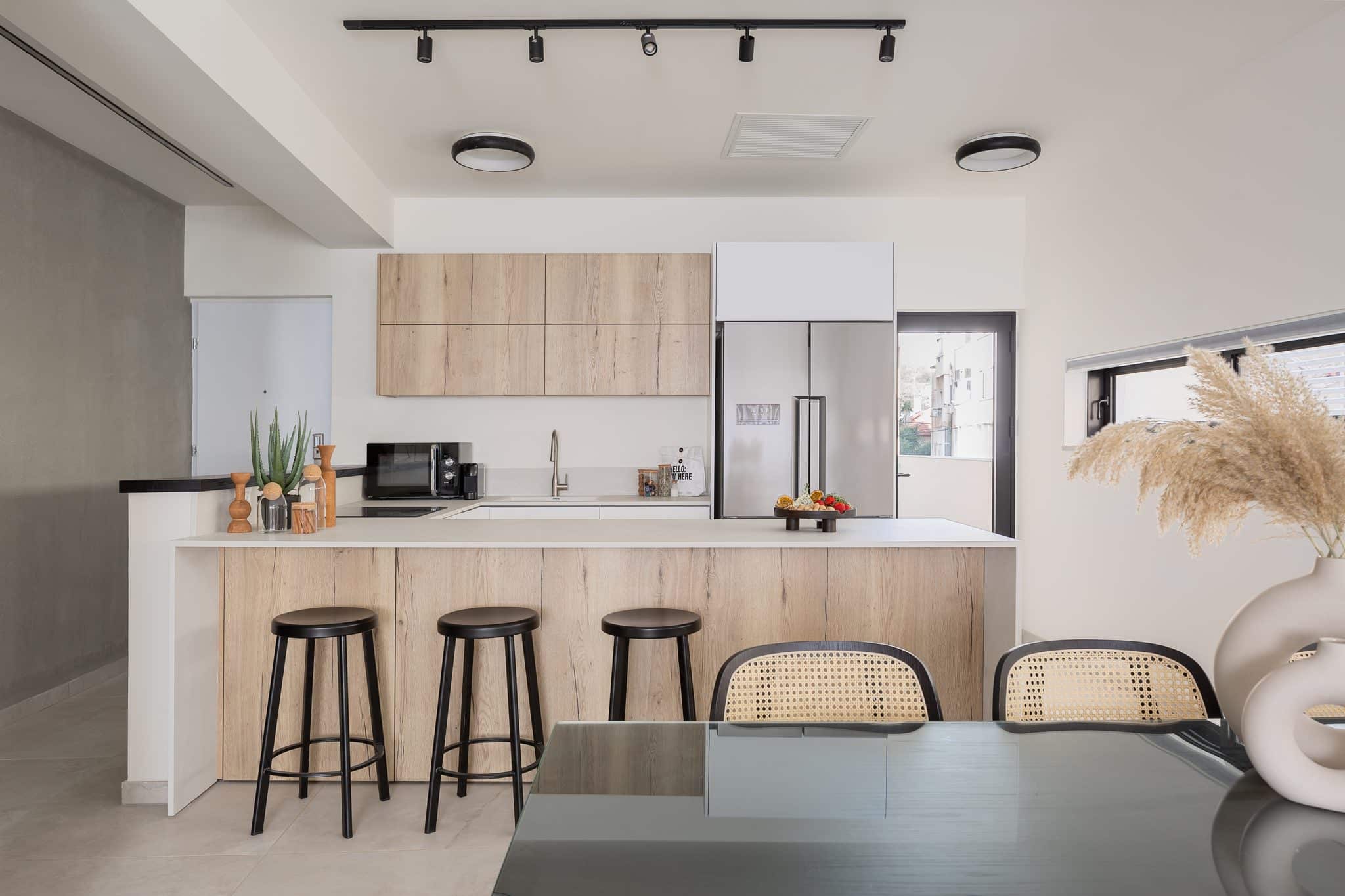 Fully equipped kitchen with island and bar stools in a TLV2GO apartment, Tel Aviv